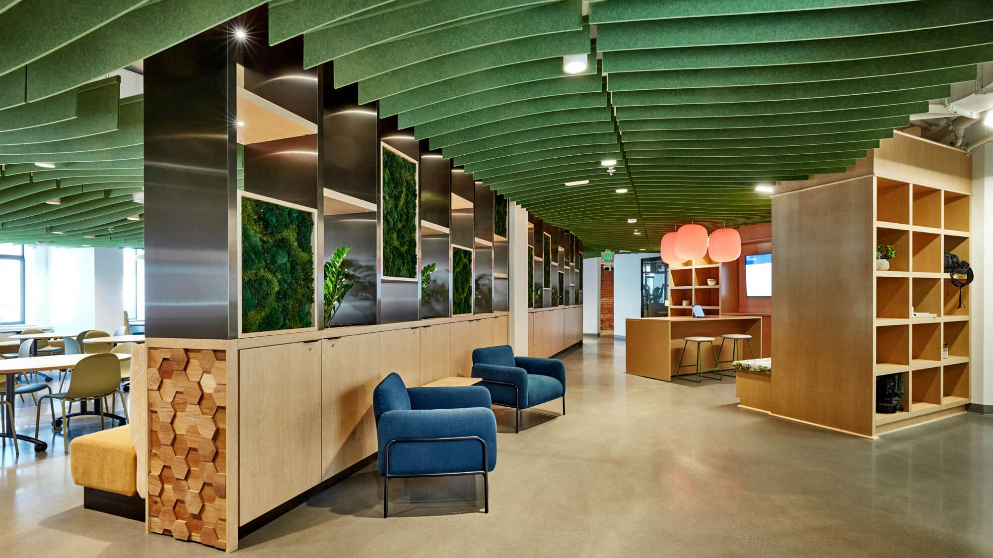 Acoustic ceiling baffles in green accentuate the lighter wood tones and mimic the greenery while minimizing sound disturbances at The Abbott, a new workspace located at 20 Brattle Street, Cambridge, Mass.