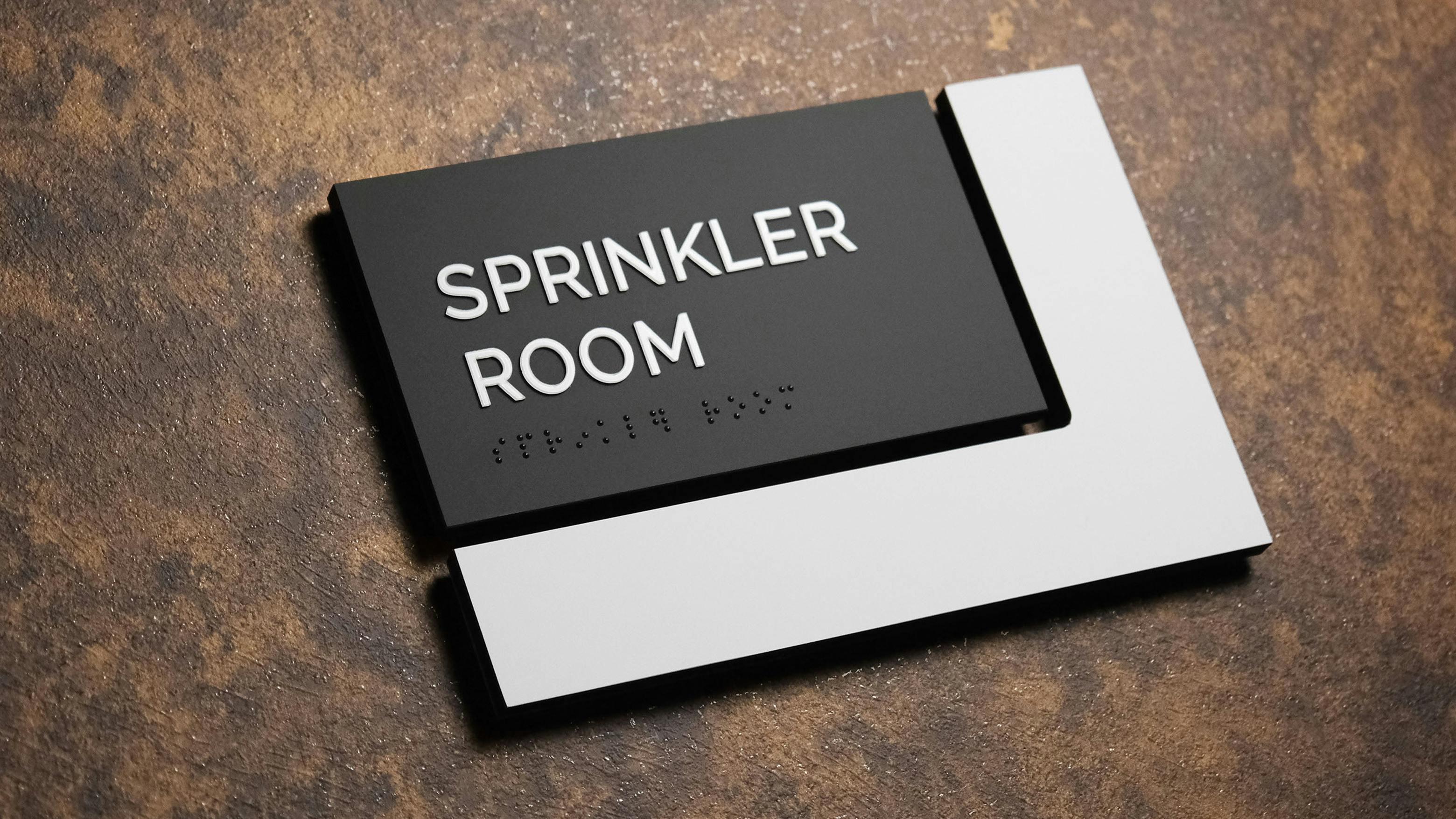 Takeform's Ell sign displaying Sprinkler Room in print and braille.