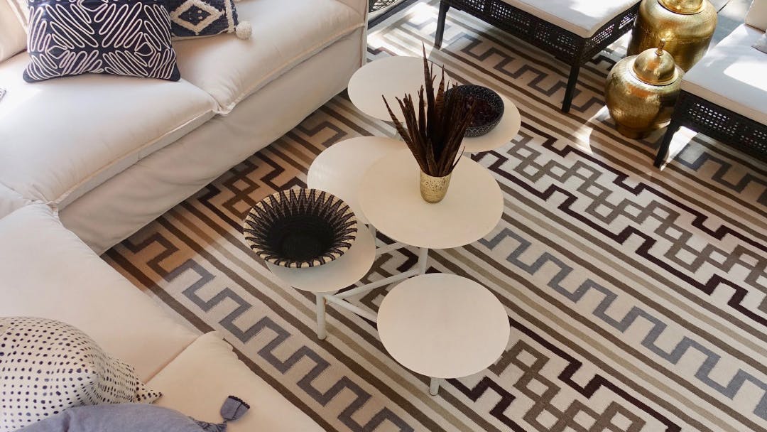 Tanzania Key Rug from the Meredith Heron Collection surrounded by couches and tables.