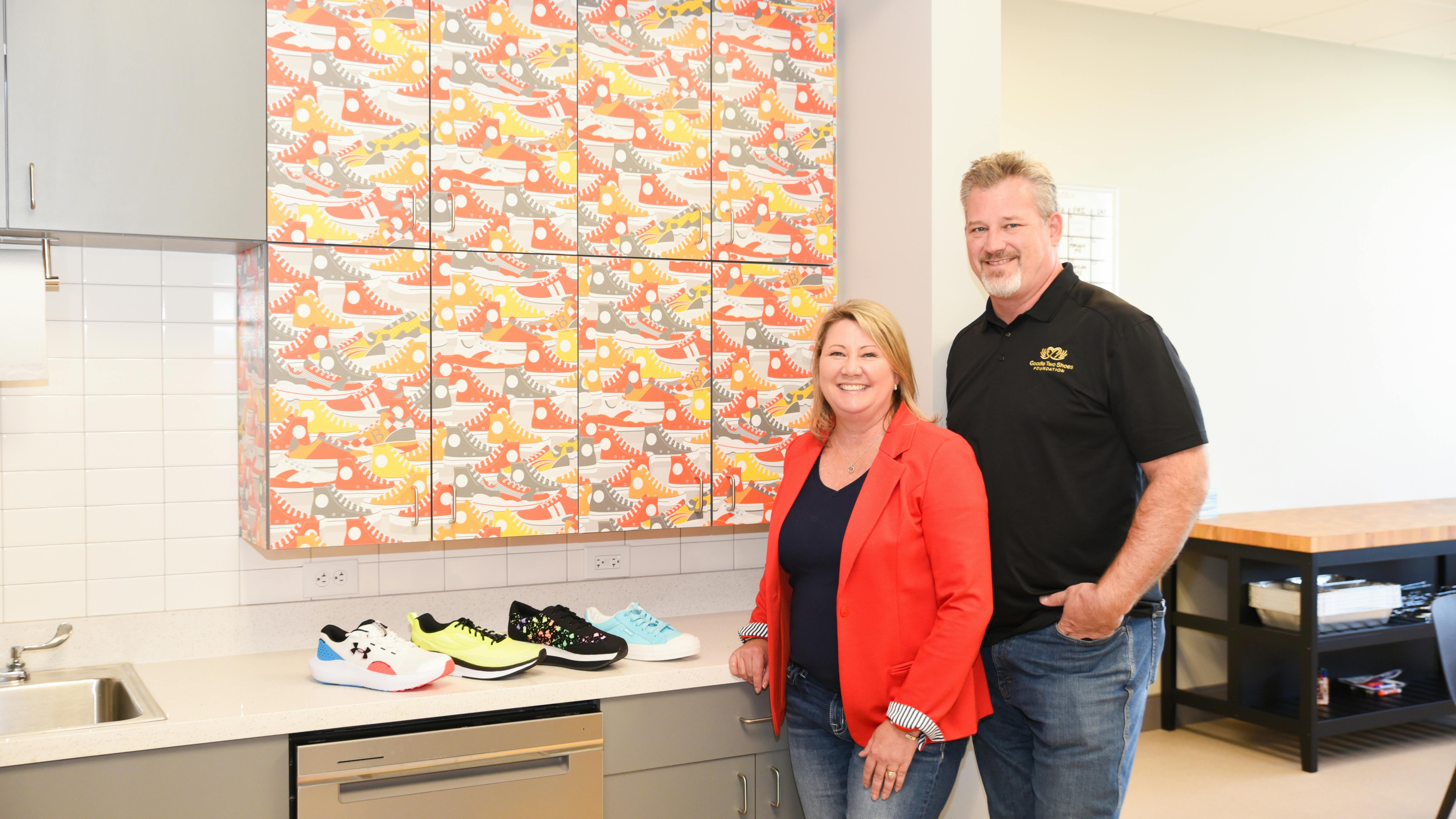 Nikki and Tony Berti, founders of Goodie Two Shoes Foundation, stand in their new office, which features a Converse graphic on the cabinetry.