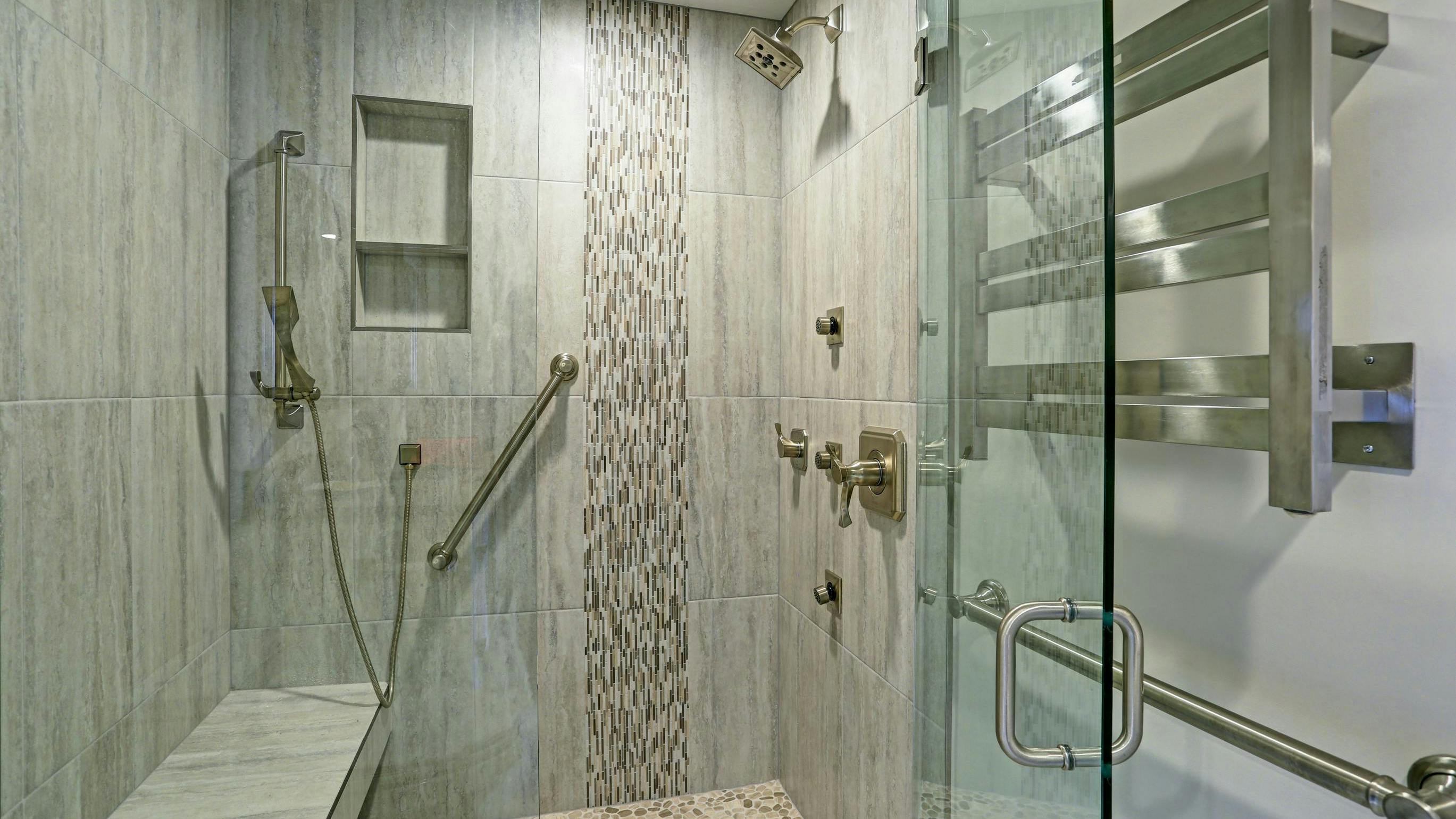 Walk-in/roll-in shower in bathroom with grab bars and removable shower head