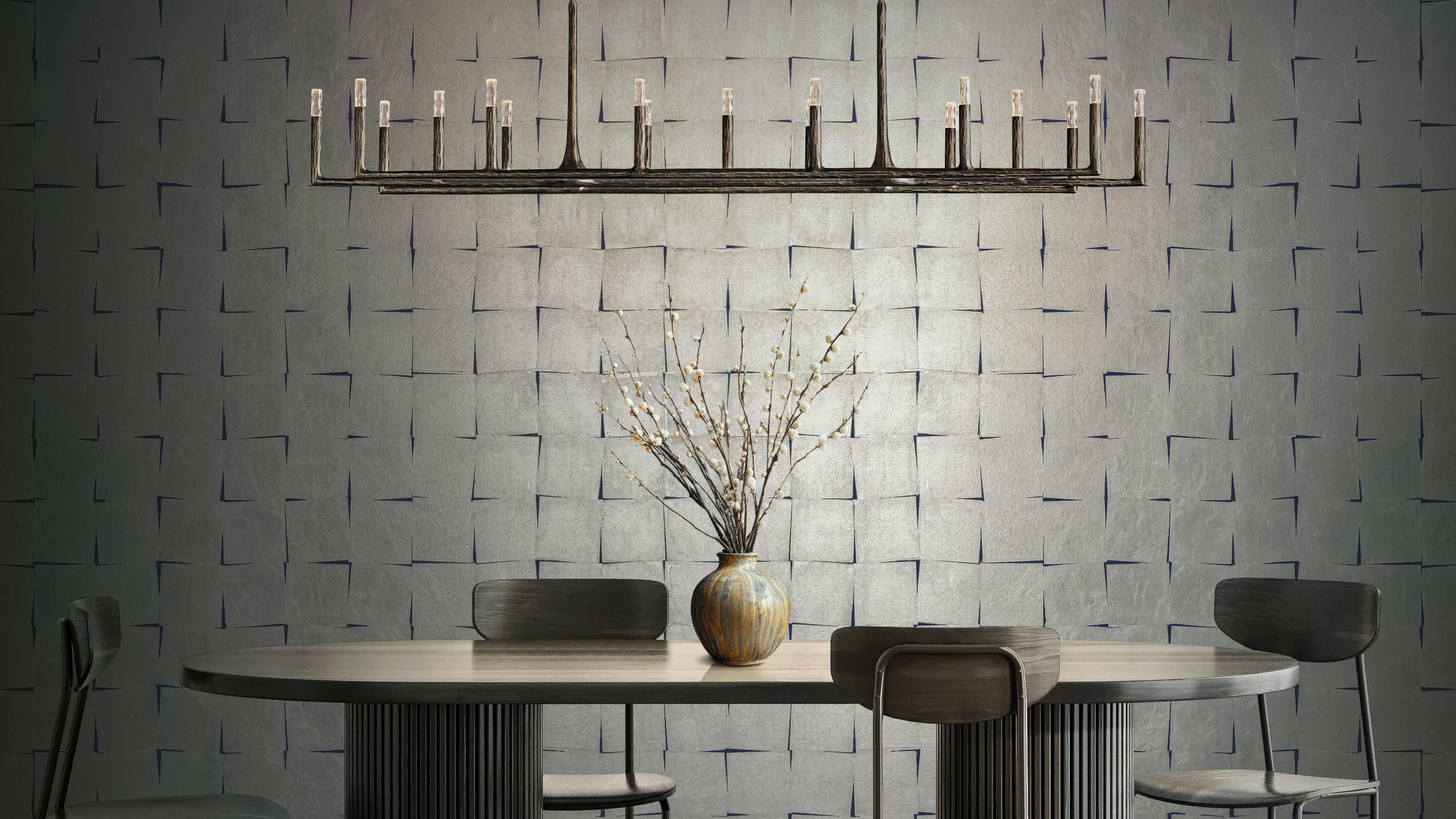 Gilded Cloth is a hand-inlaid metal leaf wallcovering, shown in a silver sapphire, installed on a wall.