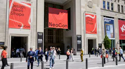 Exterior view of entrance to The MART in Chicago with NeoCon signage and people walking in front of building plaza. Exterior view of entrance to The MART in Chicago with NeoCon signage and people walking in front of building plaza.