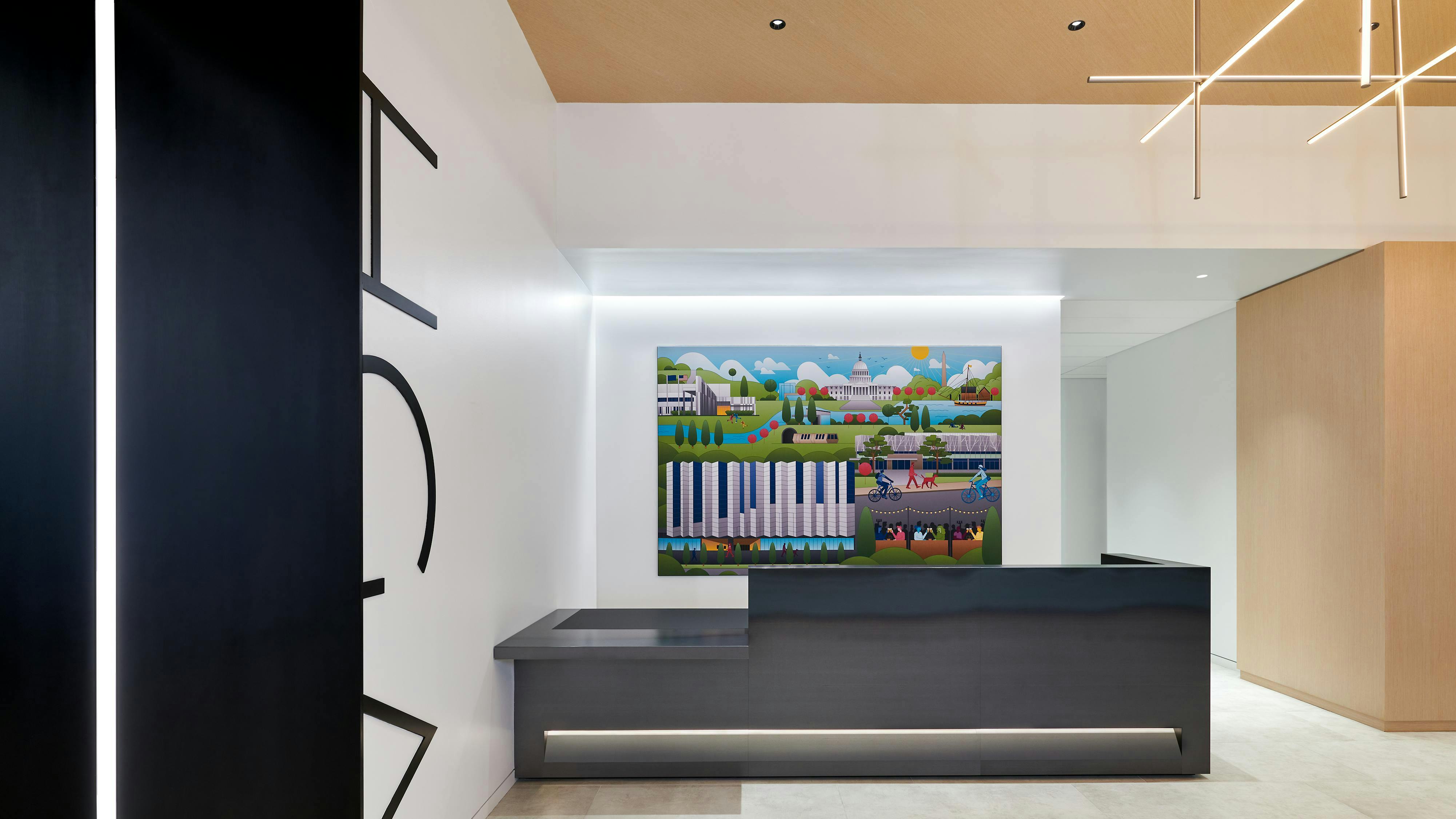 HGA's reception desk features the company's name displayed in high contrast on the wall and a curated art piece behind the desk, depicting the firm's connection to Washington, D.C.