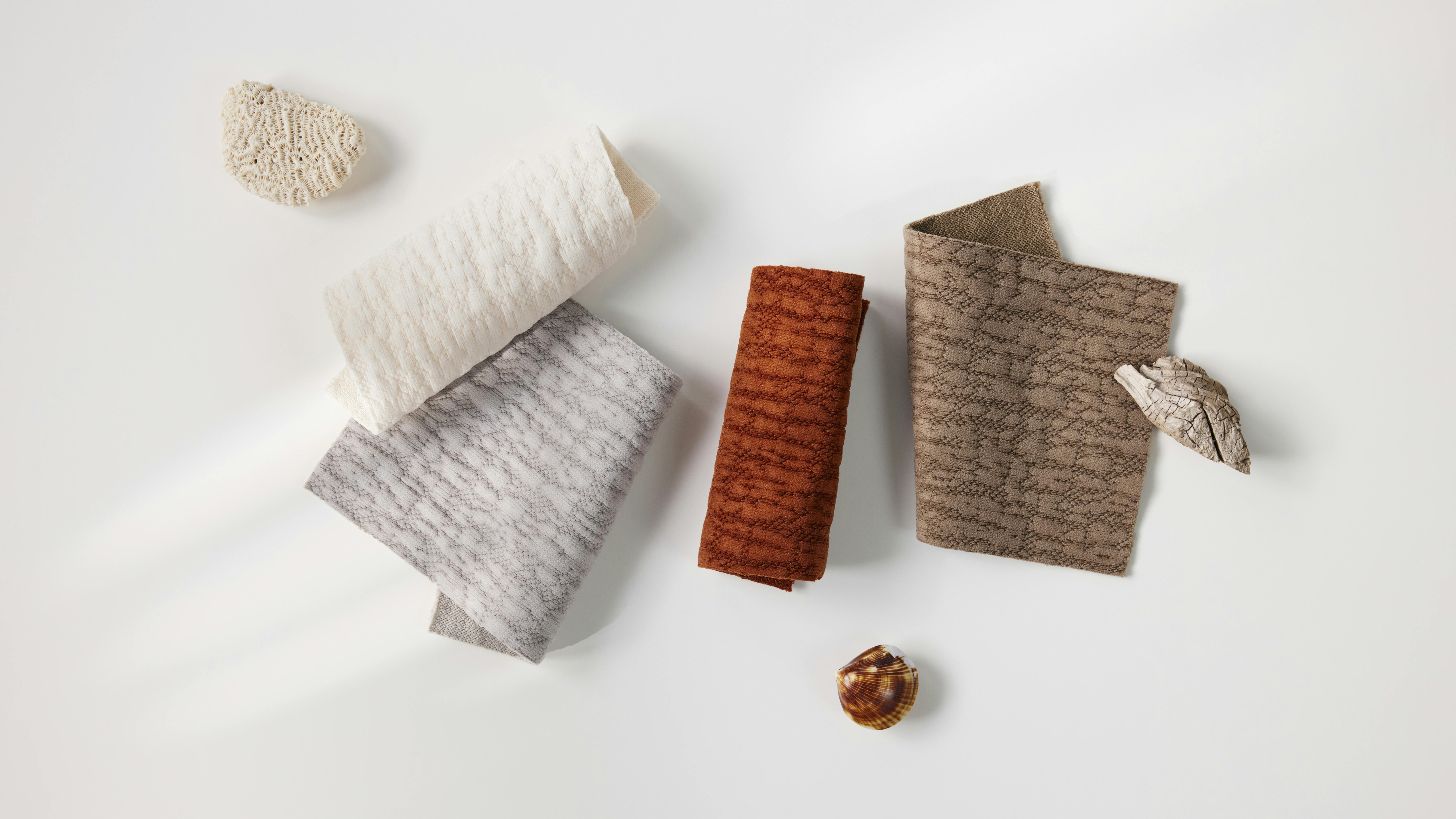 Array of fabrics in various colors against a white backdrop.
