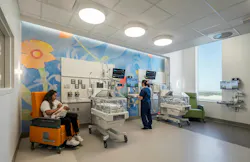 NICU space at University Health & Women's Hospital, where a woman feeds a newborn as a nurse updates medical records. NICU space at University Health & Women's Hospital, where a woman feeds a newborn as a nurse updates medical records.