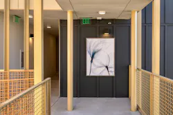 Abstract artwork of flowers seen at end of hallway with gold railings on either side. Abstract artwork of flowers seen at end of hallway with gold railings on either side.