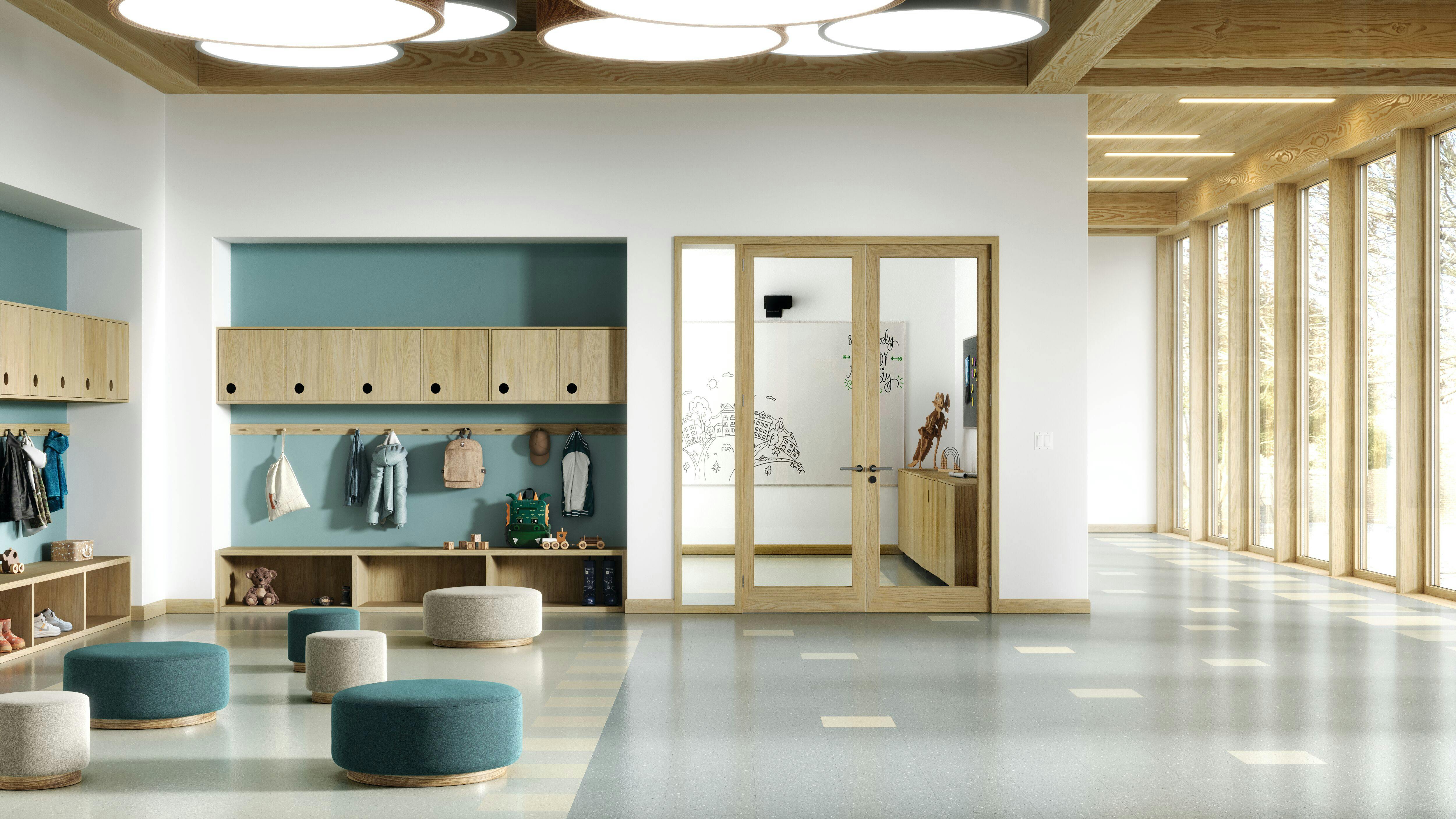 Resilient flooring featured in contemporary educational environment with circular seating pods with cubbies and hooks for hanging in background.