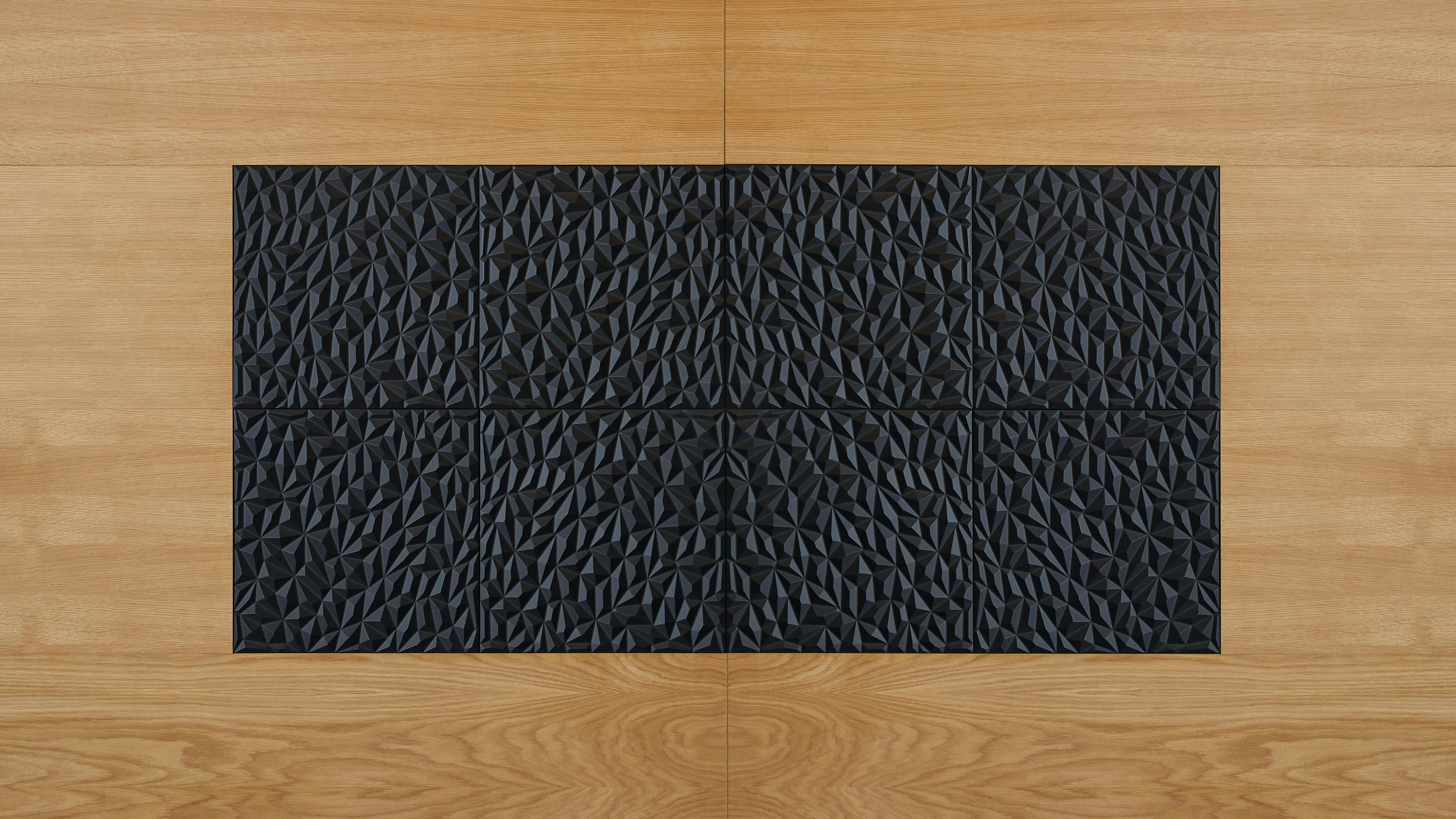 Facets panel collection, shown in black, was inspired by organic fractals and brings dimensionality and visual rhythm to spaces.