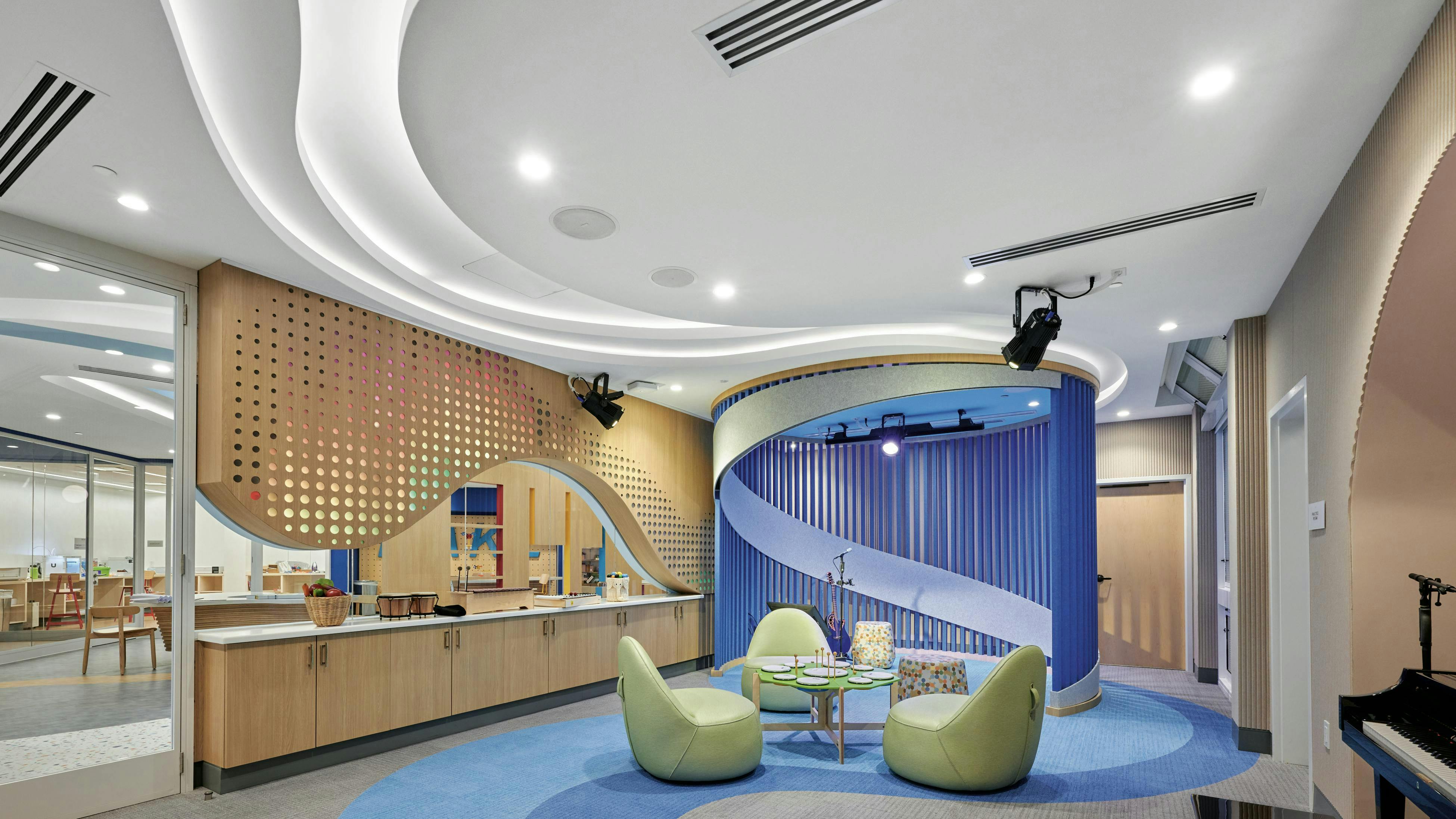 A white Acoustibuilt Seamless Acoustical Ceiling System reduces noise and speech intelligibility for privacy, while curves echoed throughout the space impart movement and progress at Children's Hospital in Memphis, Tennessee.