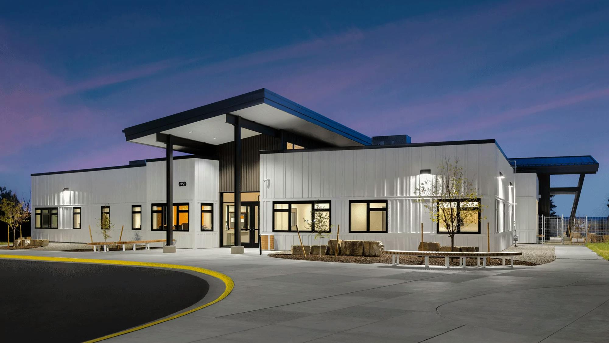 Big Horn Academy K&ndash;12 facility with white exterior cladding and clean lines, blending with the neighborhood aesthetic and honoring local Native American culture.
