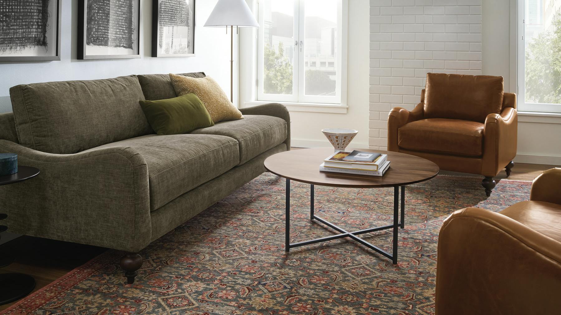 The Eloise Chair is handcrafted with a benchmade hardwood frame. The chair is positioned beside a sofa in a living room.