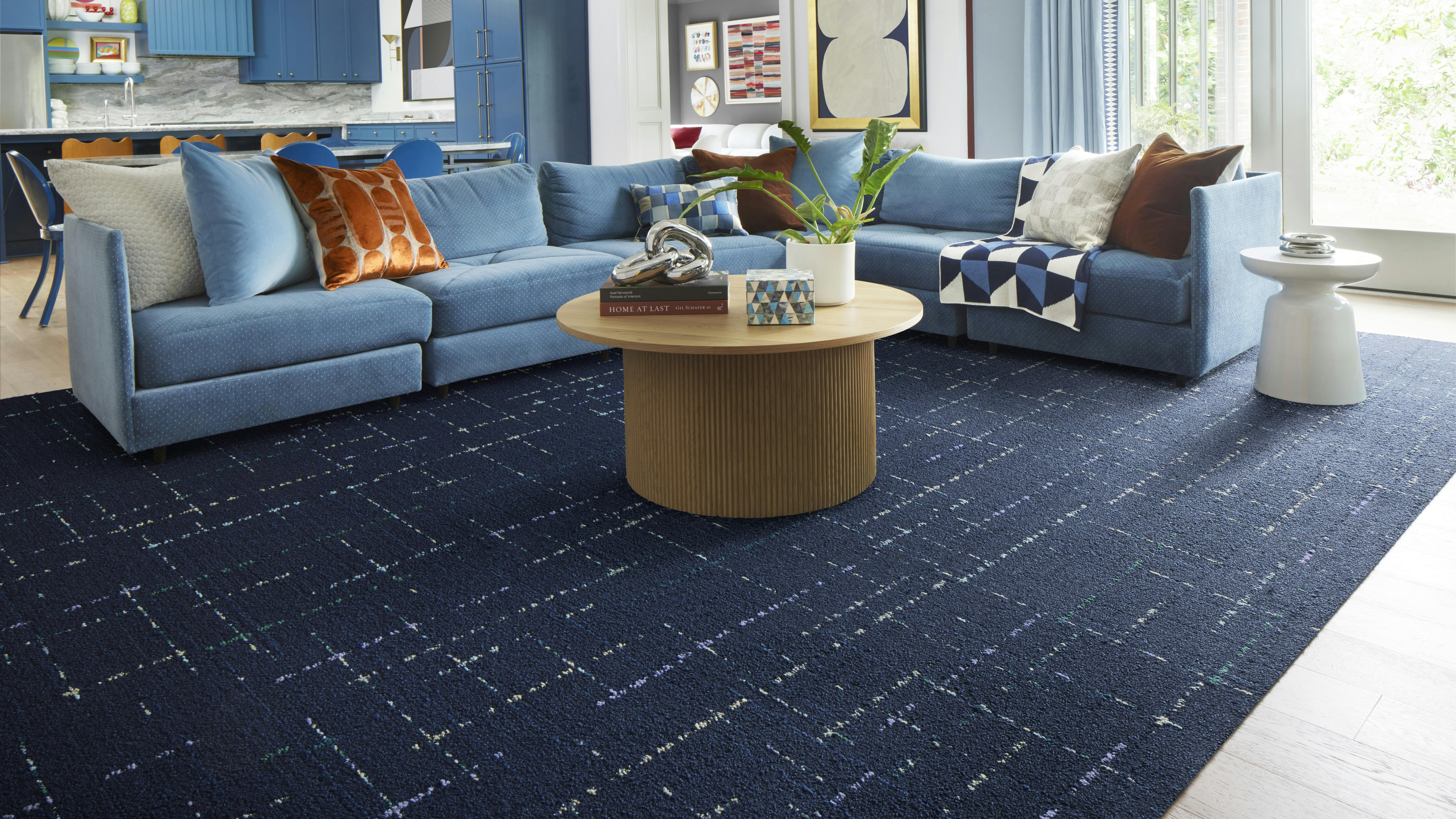 On Repeat carpet tile shown in Navy/Turquoise from FLOR cushions a living room floor.