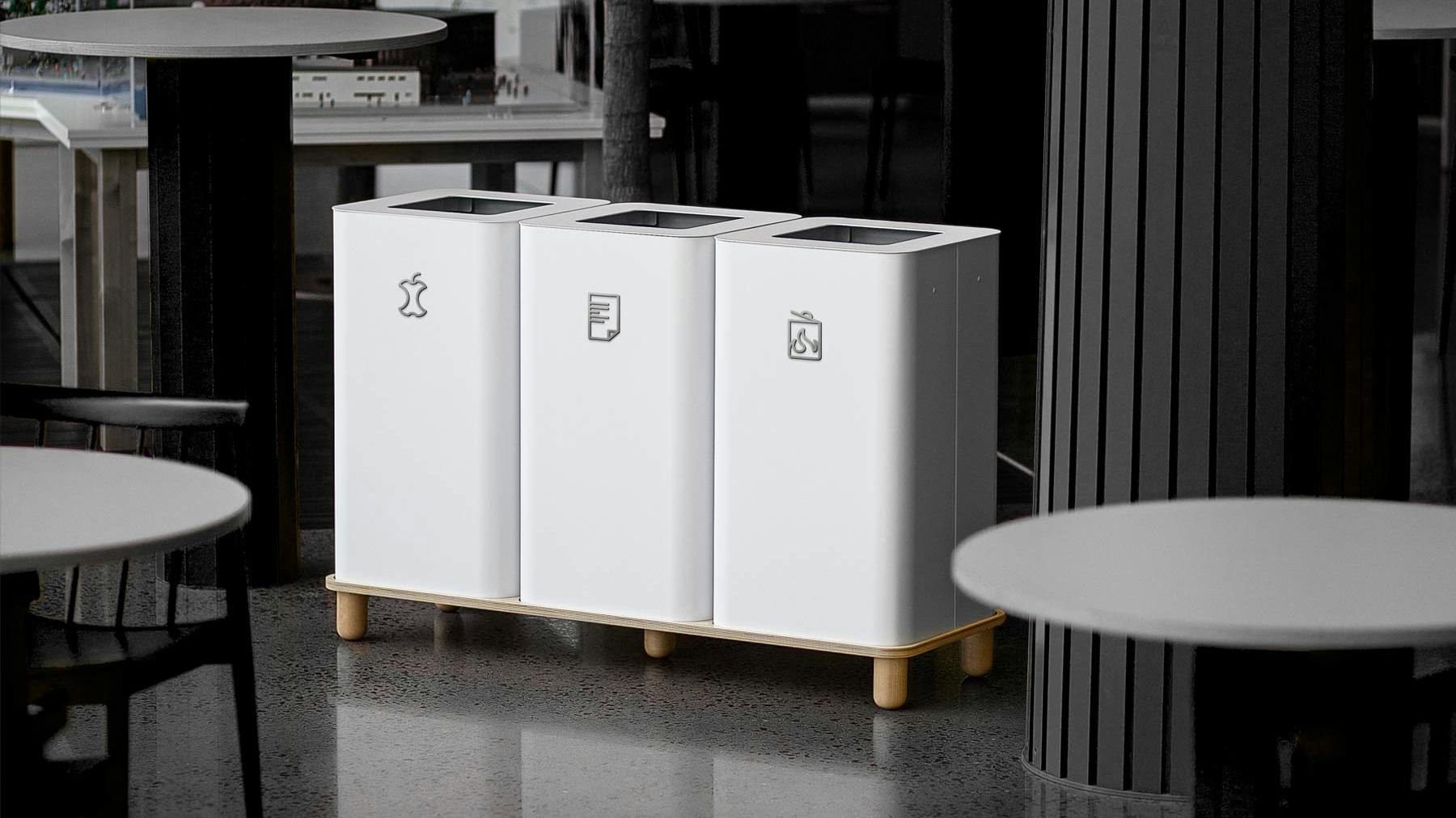 A trio of Arkad Recycling Bins shown in white and set on wooden stands.