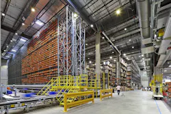 Manufacturing space with exposed structural elements and bright orange HVAC components visible. Manufacturing space with exposed structural elements and bright orange HVAC components visible.