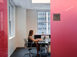 Conference room offers privacy and dynamic lighting effects through translucent rose-colored glass panels. Conference room offers privacy and dynamic lighting effects through translucent rose-colored glass panels.