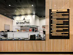 Food vendor counter with menu on wall featuring wood slatted front paneling. Food vendor counter with menu on wall featuring wood slatted front paneling.