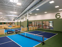 Indoor pickleball courts with green and blue markings for zones of play. Indoor pickleball courts with green and blue markings for zones of play.