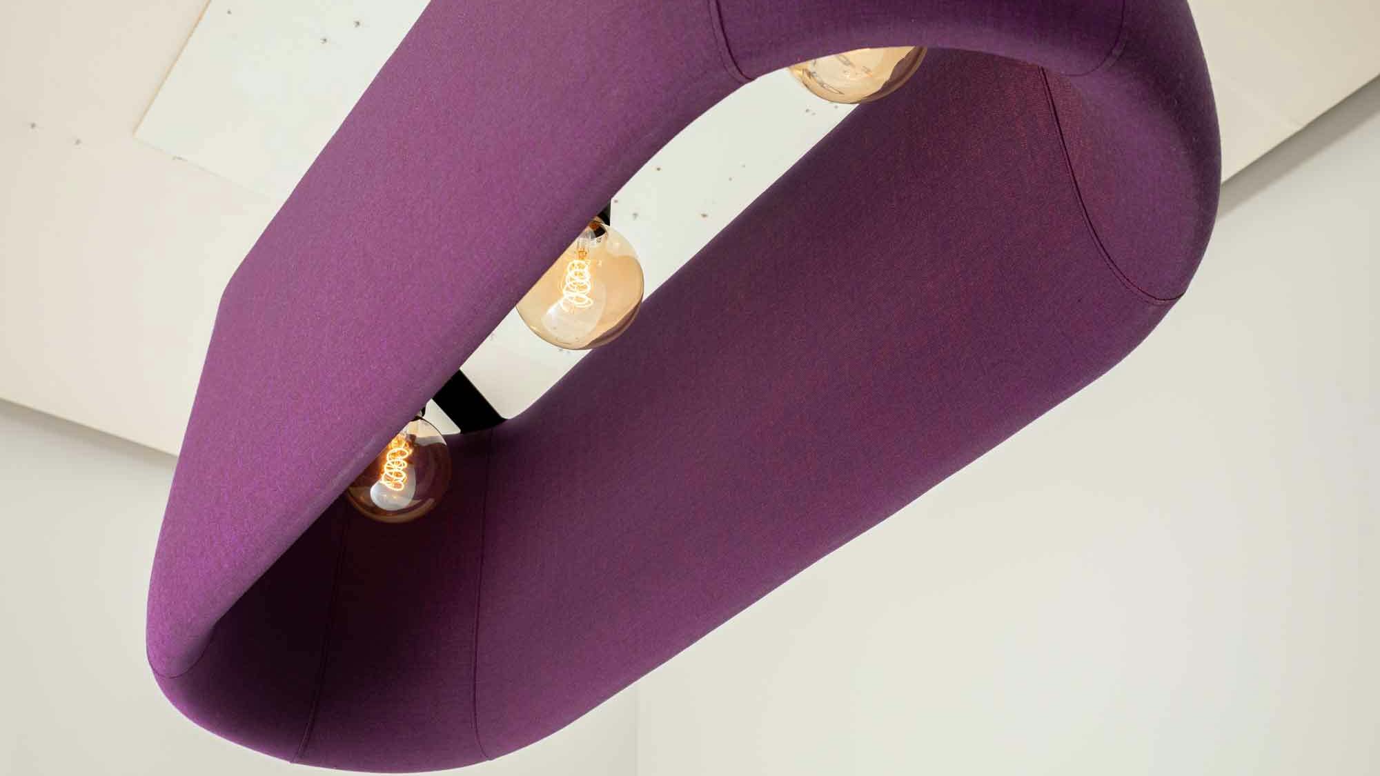 The BuzziProp Beam combines acoustic performance and ambient lighting. It also brings a splash of color to any space. The beam is shown in purple.