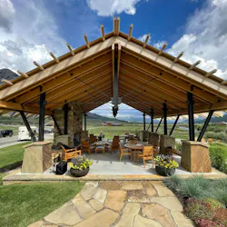 Exposed steel and timber pavilion with stone fireplace shows clear views of mountain, river, and forests. Exposed steel and timber pavilion with stone fireplace shows clear views of mountain, river, and forests.