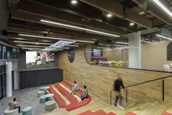 Wide view of the Town Hall hub showing an open, multifunctional gathering area that connects adjacent work and social zones. Wide view of the Town Hall hub showing an open, multifunctional gathering area that connects adjacent work and social zones.