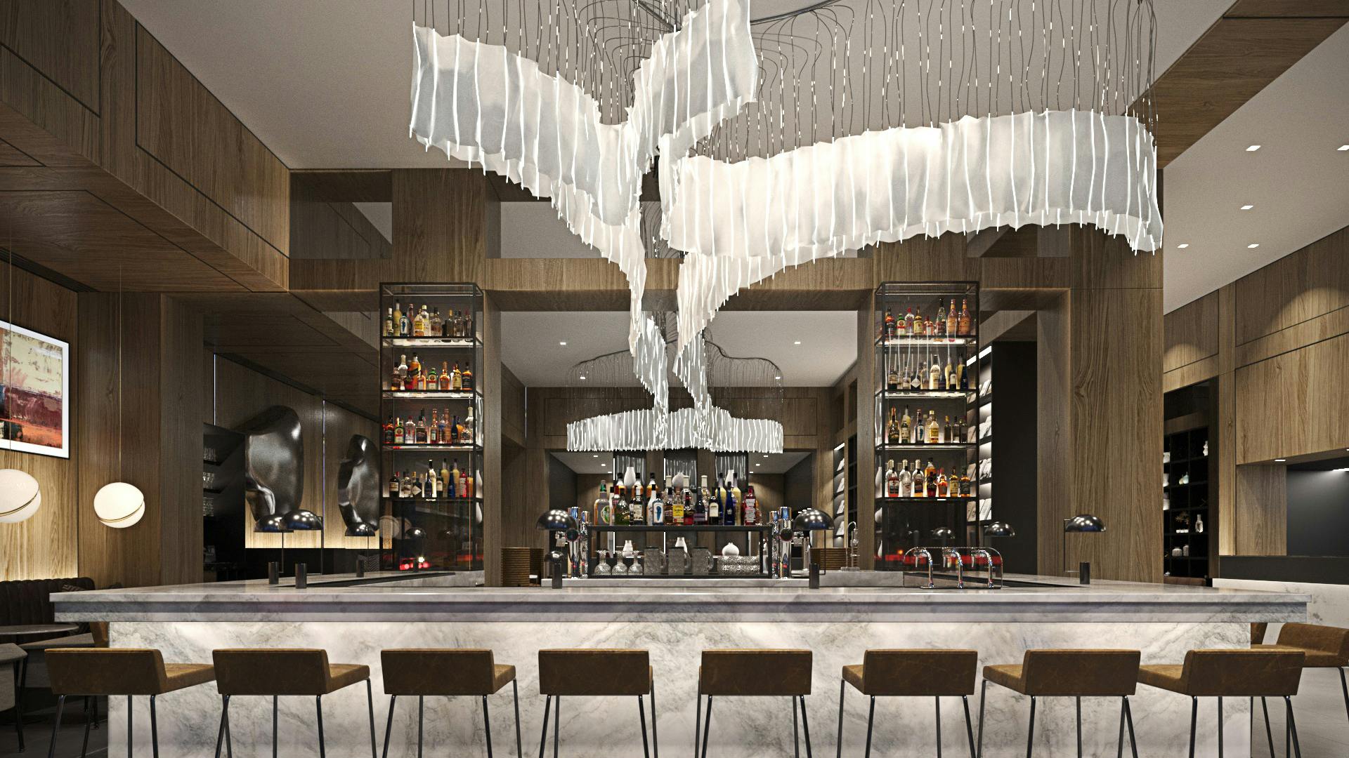 Natural stone bar with stools and dramatic lighting fixture overhead in the AC Hotel by Marriott in Washington, DC..
