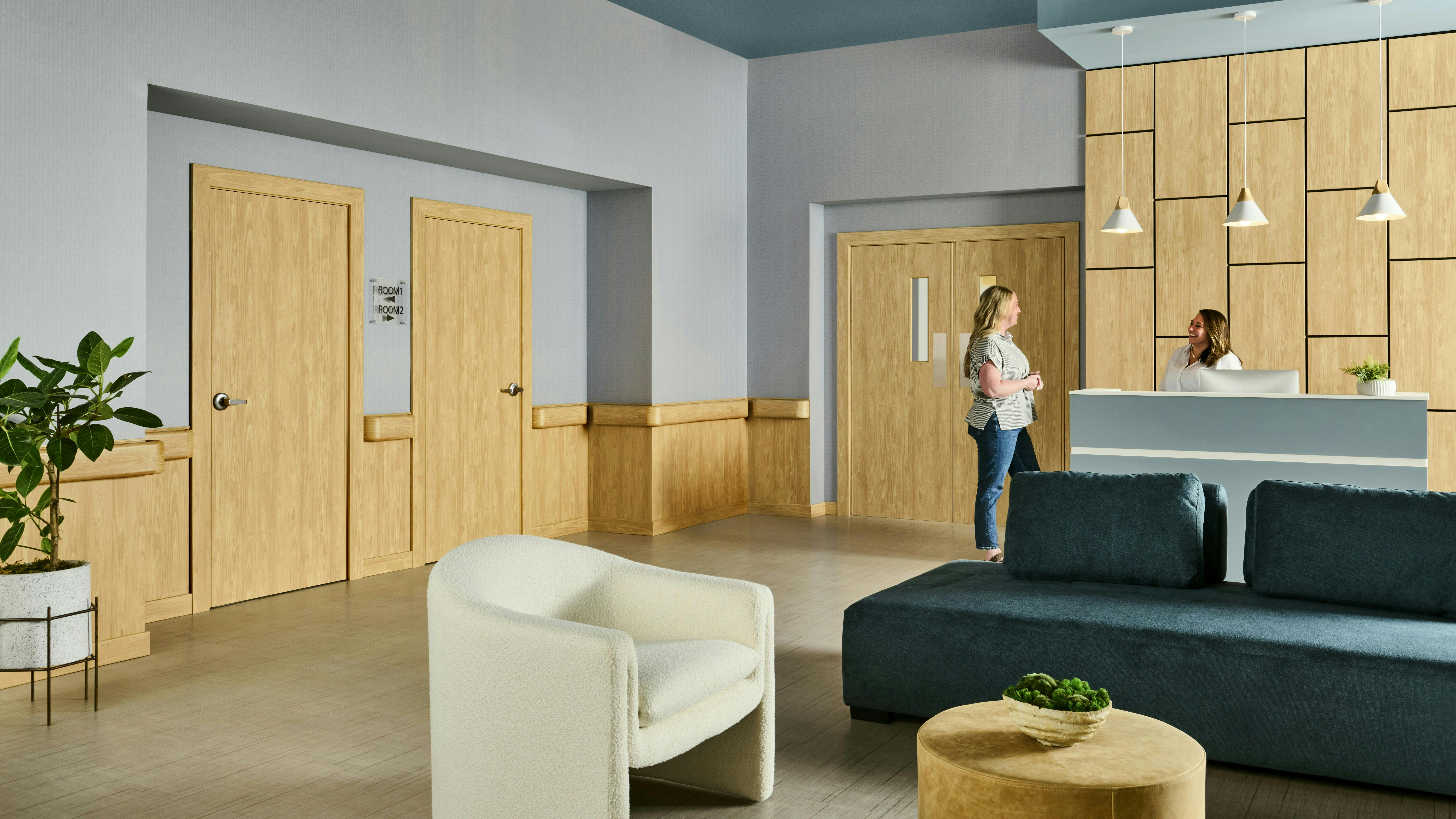 Treatment center lounge area for visitors and staffs with lounge seating and wood wall paneling.