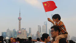 A Chinese boy waves a national flag from atop his fathers shoulders A Chinese boy waves a national flag from atop his fathers shoulders