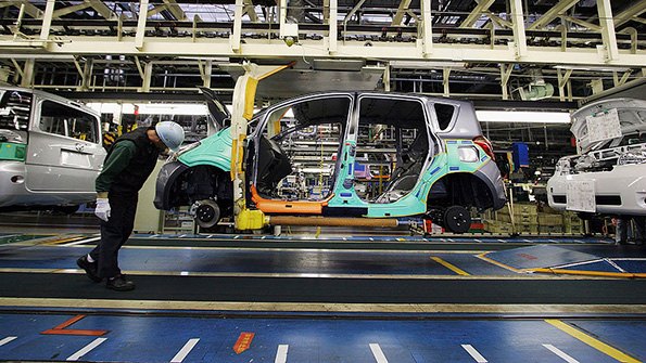 A Toyota worker inspects a car at the companys Takaoka plant