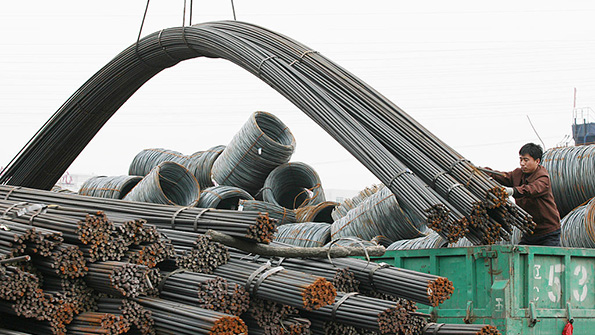 A worker loads steel onto a truck at a wholesale market in Liaoning Province