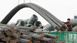 A worker loads steel onto a truck at a wholesale market in Liaoning Province A worker loads steel onto a truck at a wholesale market in Liaoning Province
