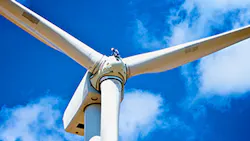 A wind turbine technician works high above the ground A wind turbine technician works high above the ground