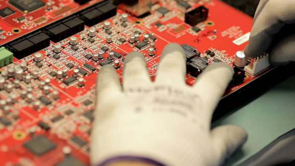biamp systems employee places connectors on a Nexia board