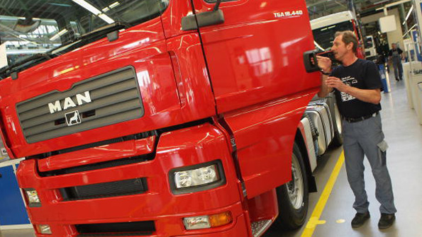 A worker inspects a MAN truck