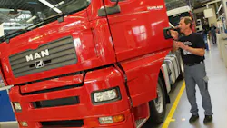 A worker inspects a MAN truck A worker inspects a MAN truck