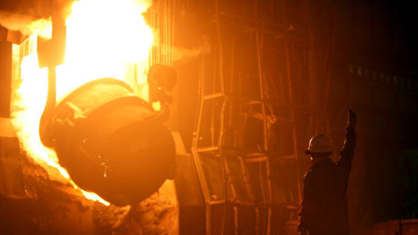 A worker monitors a furnace dumping steel waters at a Chinese plant