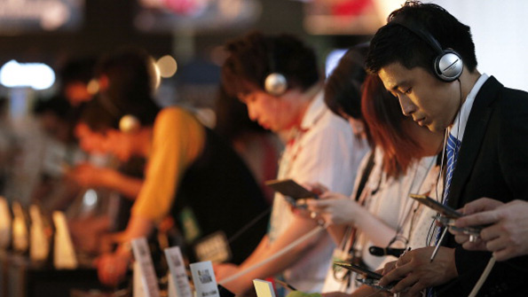 Tokyo Game Show attendees play with handheld consoles