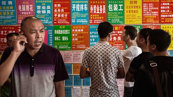 Job seekers look at ads outside an employment center in the city of Yiwu China