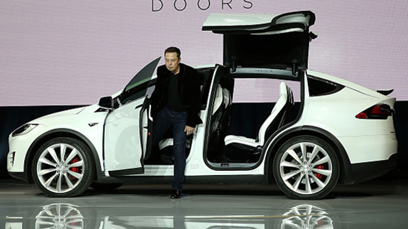 Tesla Motors CEO Elon Musk emerges from the new Model X