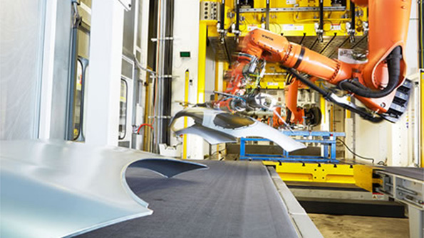 An industrial assemblyline robot works on auto panels