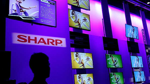 A CES attendee looks at the wall of screens in the Sharp booth