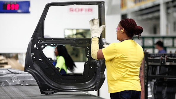 A worker handles a door at the Fiat Chrysler Warren Mich Stamping Plant earlier this year