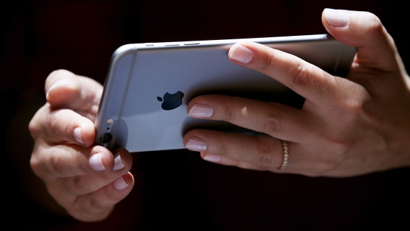 A user holds an Apple iPhone 5