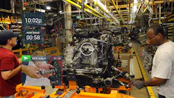 Workers assemble equipment while referencing a headsup display HUD Workers assemble equipment while referencing a headsup display HUD