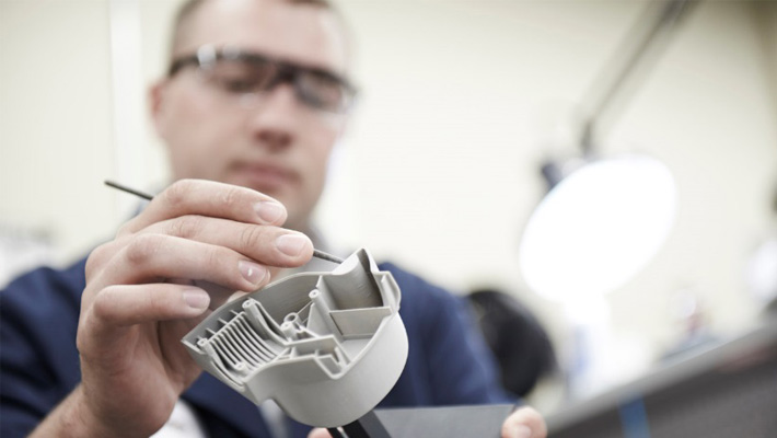 A worker designs a part for manufacturability.