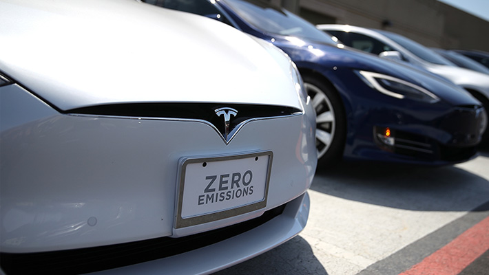 A row of Tesla sedans on a lot.