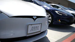 A row of Tesla sedans on a lot. A row of Tesla sedans on a lot.