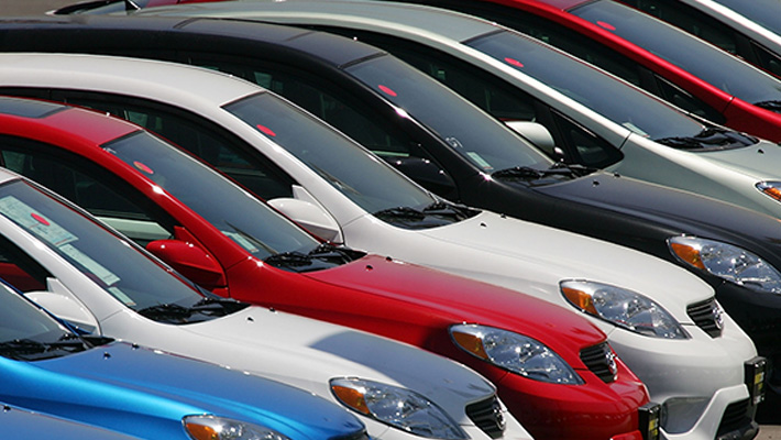 A row of Toyota sedans on a dealership lot.