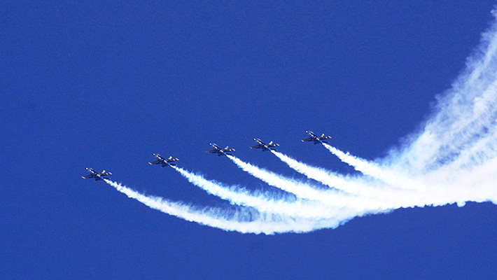 A group of Blue Angels flies in unison.