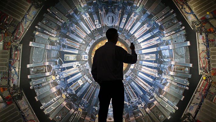 A man stands in front of the Large Hadron Collider at the Science Museum in London.